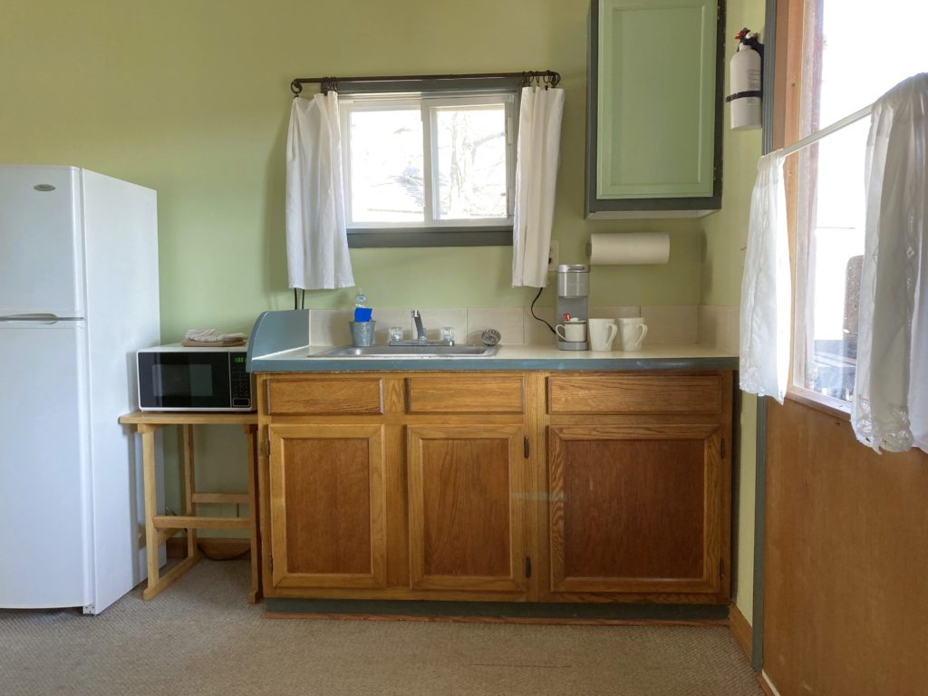 Kitchenette with fridge coffee sink and microwave