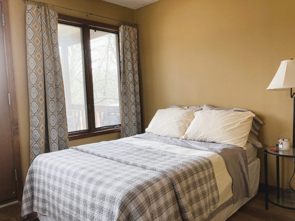 full bed with quilt in yellow room