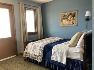 Bed with quilt in blue room